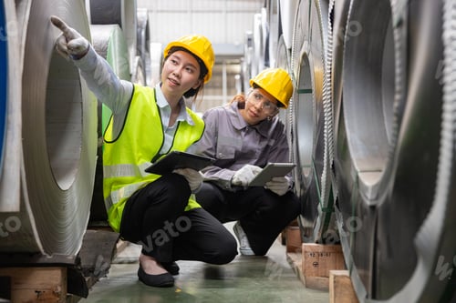 Preview: A female engineer is inspecting steel plates in a factory.