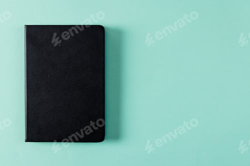Preview: Close up of black notebook with copy space on green background