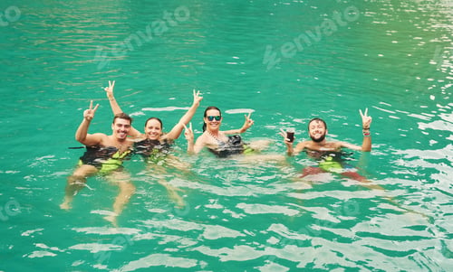 Preview: Getting a feel for the water. High angle portrait of a group of young friends swimming in a lake.