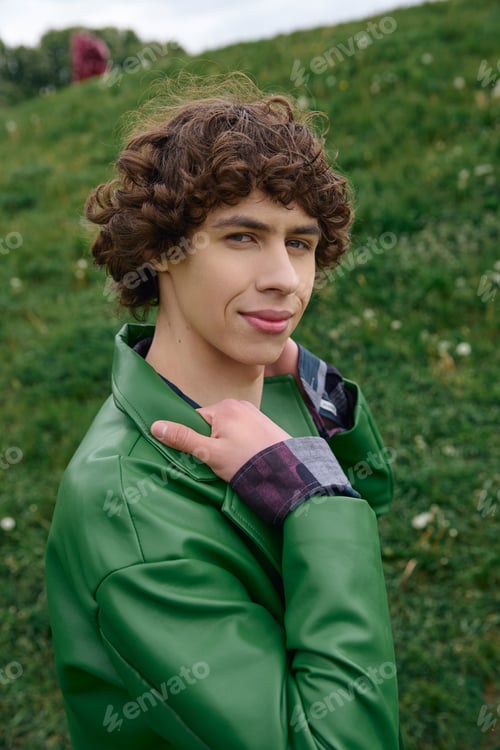 Preview: Young handsome student enjoying a peaceful walk through a sunlit outdoor park area