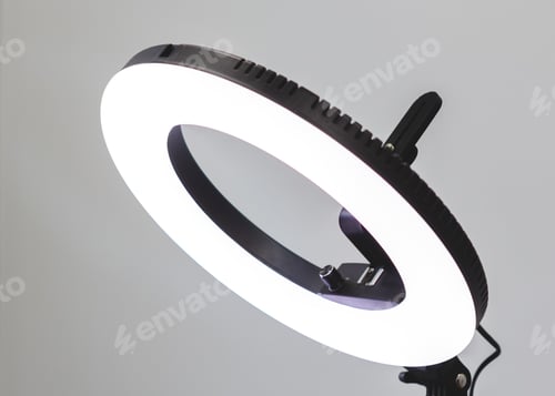 White lit up ring light for portrait photography in front of a plain white background