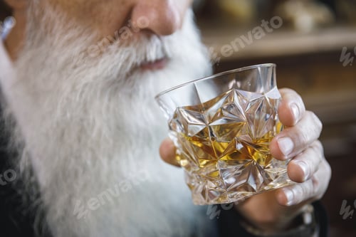 Preview: Handsome bearded senior man with a glass of whiskey