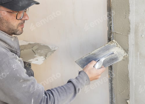 Preview: Craftsman uses a float trowel and cement to plaster a house wall. Construction process