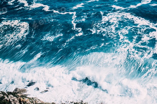 Preview: top down shot of waves crashing at rocks