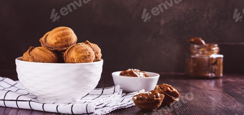 Preview: A bowl of cookies nuts filled with boiled condensed milk on a board web banner