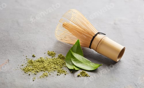 Preview: Matcha tea with chasen bamboo whisk and tea leaves on graphite background