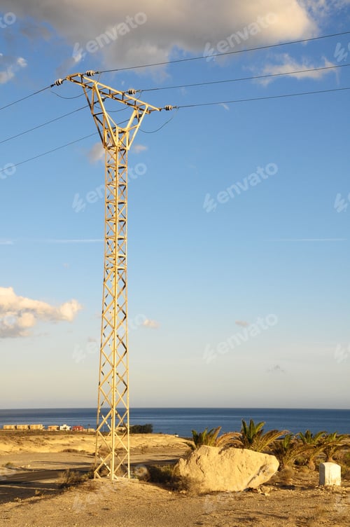 Preview: Vertical shot of an electricity pole on the shore on a sunny day