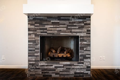 Preview: Gray fireplace with unlit firewood inside on a white background of living room wall