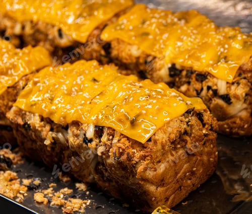 Preview: Exquisitely shaped delicious bread on a steel tray, illuminated by warm lights