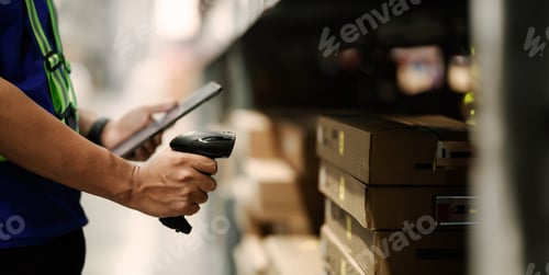 Preview: A person is scanning a barcode with a tablet. The person is wearing a green vest.