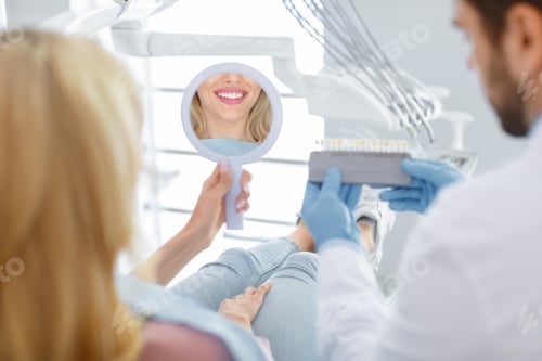 Preview: Dentist applying sample from tooth scale to patient teeth reflection