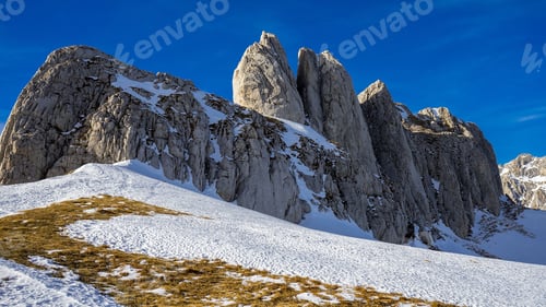 Preview: Majestic snow-covered mountain peaks under a vibrant blue sky
