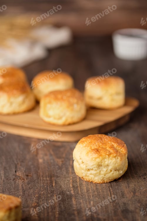 Preview: group of scones on wood plate with jam on table
