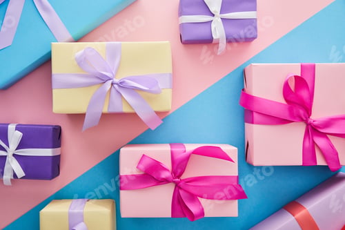 Preview: top view of colorful gift boxes with ribbons and bows on blue and pink background