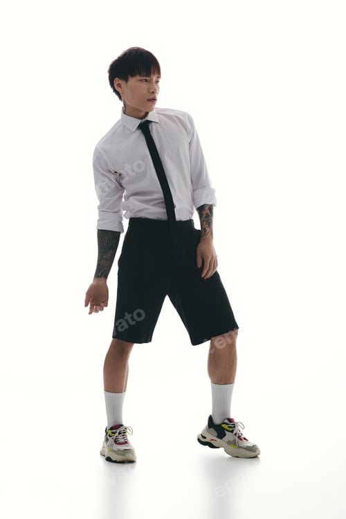 Preview: Stylish young man showcases unique fashion in a modern and bright studio setting