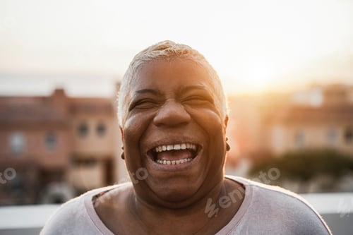 Preview: Portrait of happy senior african woman smiling on camera outdoor in the city - Focus on face