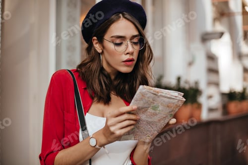 Preview: Amazing brunette with red lipstick and shirt, glasses, beret concentrated looking for something in
