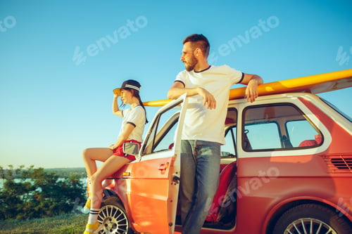 Preview: Couple sitting and resting on the beach on a summer day near river