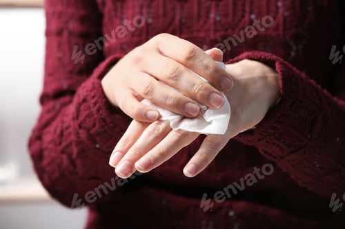 Preview: Woman cleaning hands with paper napkin, closeup