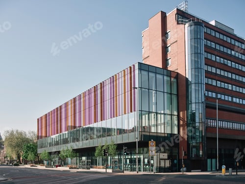 Preview: Modern architecture featuring colorful glass panels on a city street at sunrise.