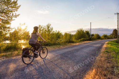 Preview: Adventurous White Cacasusian Woman riding a bicycle on a road