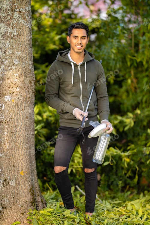Preview: Environmental protection volunteer holding plastic garbage and mechanical grabber