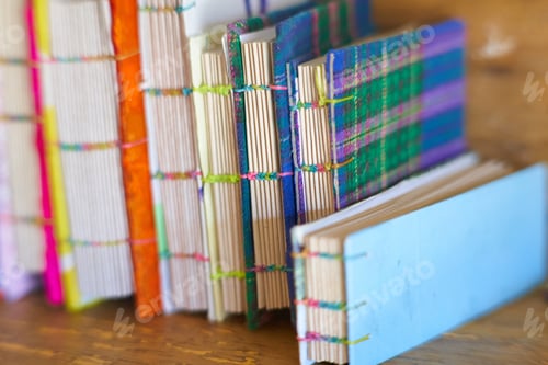 Preview: Closeup shot of books with colorful covers bound with rubber bands