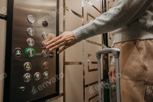 Preview: Hand pressing elevator button inside hotel lift