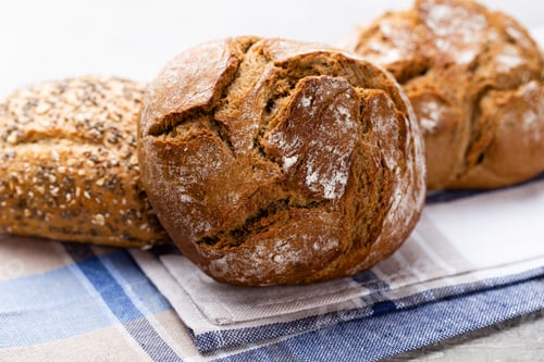Preview: Freshly baked bread on dark gray kitchen table, top view.