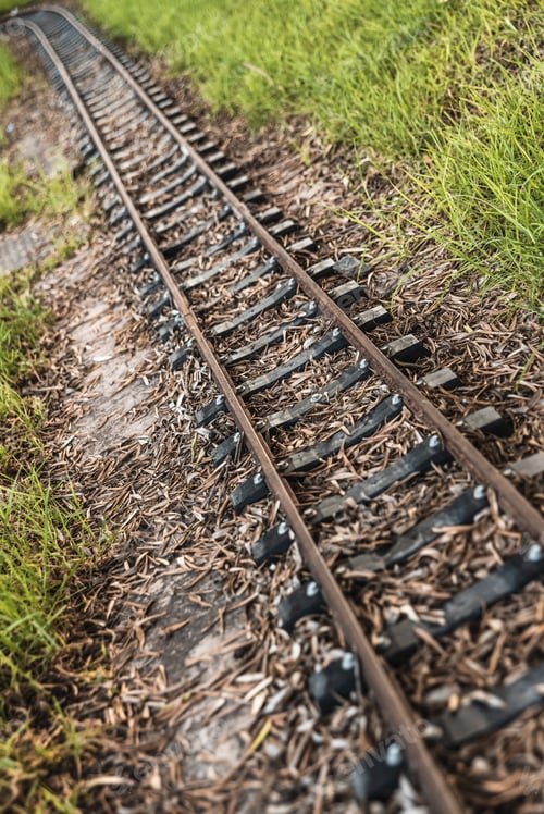 Preview: Old miniature train tracks at sunset.