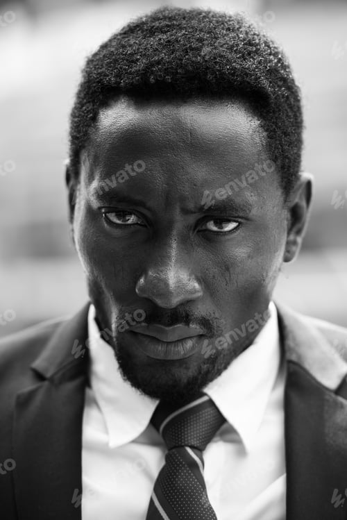 Preview: Face of stressed African businessman looking angry in black and white