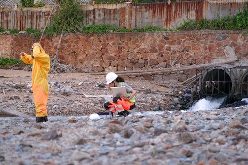 Preview: scientists in PPE gear analyzing seawater samples using test tubes and a laptop