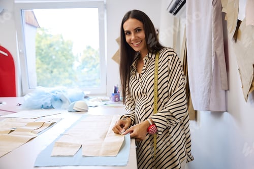 Preview: Designer lays out patterns on blue fabric
