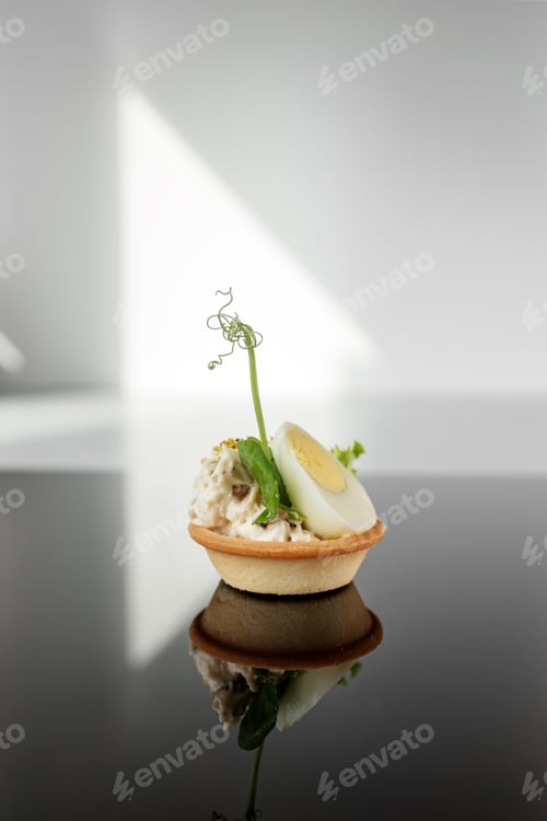 Preview: Exquisite appetizers from chef. Close-up of tartlet with quail egg and chicken and microgreens