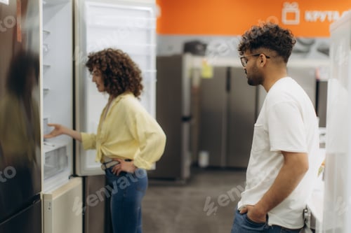 Preview: Couple Exploring Refrigerators in Electronics Appliance Store Showroom