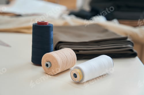 Preview: Thread and fabric on desk inside tailor workshop