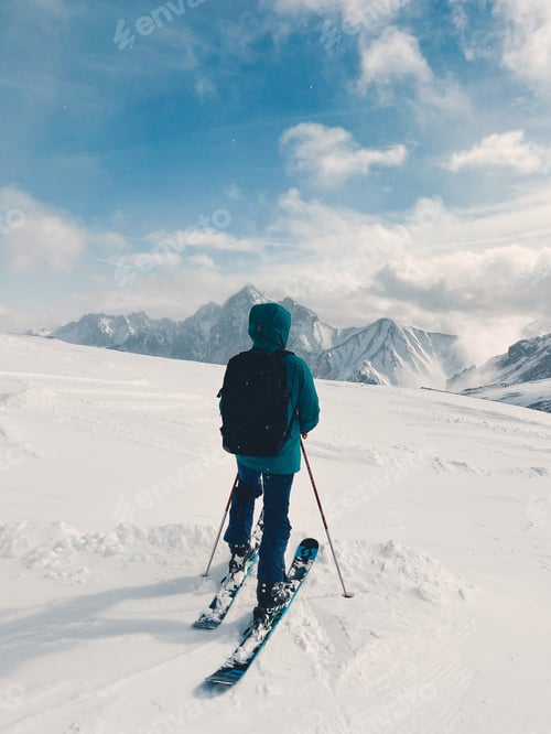 Preview: Male skier in front of snow covered mountains