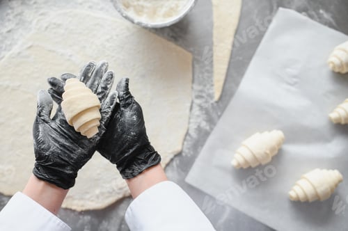 Preview: Baker showing freshly made croissant in bakery