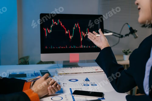 Preview: Two businesswomen are having a discussion about stock market investments, using graphs displayed on