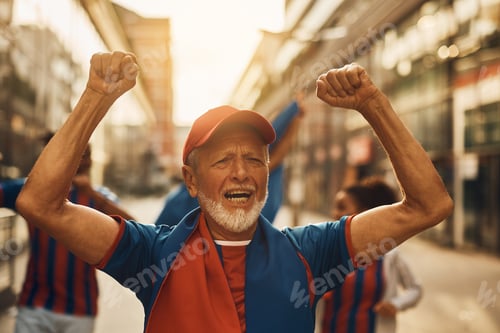Preview: Cheerful senior soccer fan cheering on the street.