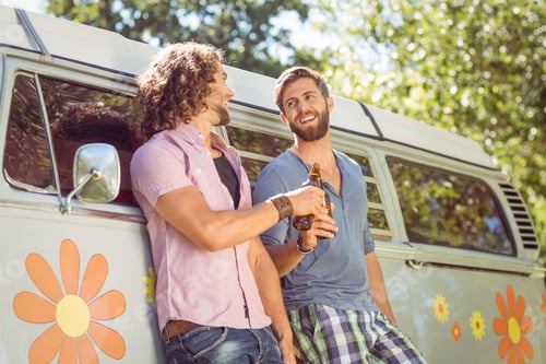 Preview: Hipster friends toasting with beers on a summers day