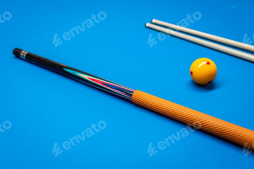 Preview: Cue sticks and a yellow ball on a billiard table.