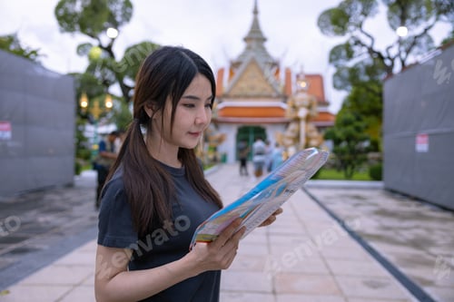 Preview: Tourists Examining Map Near Illuminated Temple