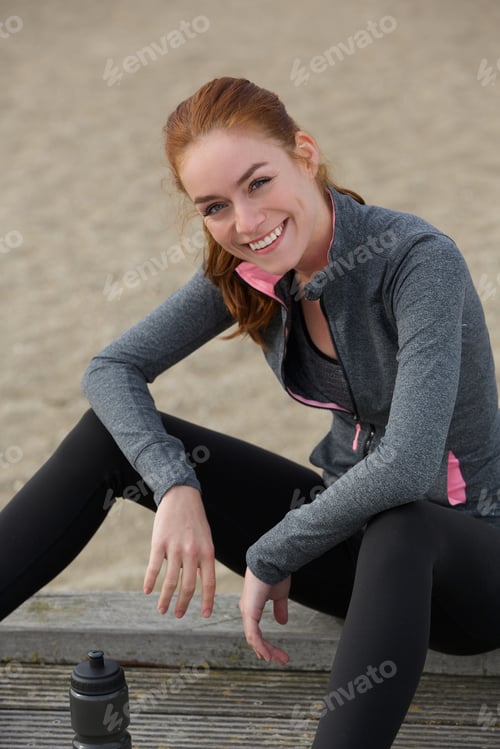 Preview: Smiling sports woman sitting outdoors