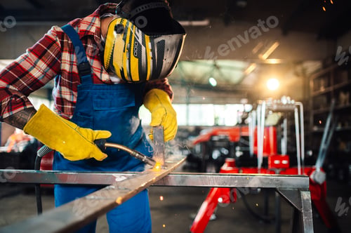Preview: Hard worker in a dangerous work environment welding metal construction