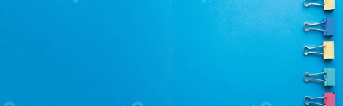 Preview: top view of colorful pastel fold back clips on blue, banner