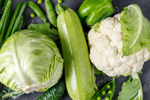 Preview: Background of organic green raw vegetables on black table. Top view of healthy organic food.