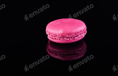 Preview: Assorted colorful macarons folded and arranged on a black surface with reflection