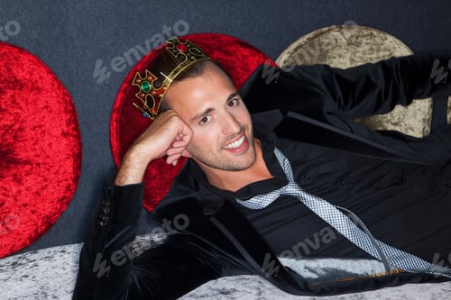 Preview: Smiling man wearing plastic crown in bar