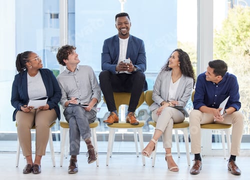 Preview: Portrait of a young businessman sitting on a chair alongside candidates in an office